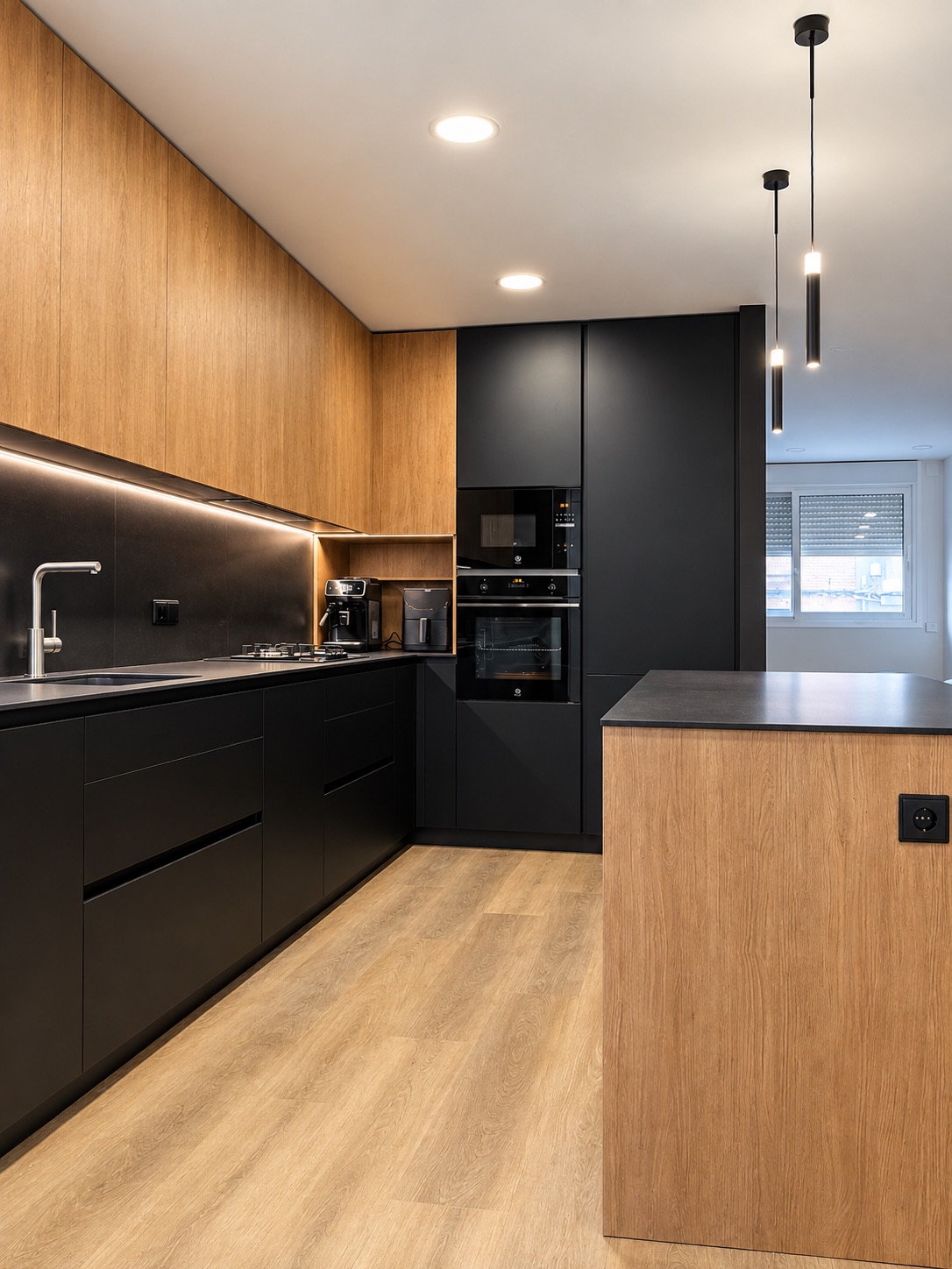 Cocina con muebles altos de roble, luz LED bajo los muebles y lámparas colgantes sobre la isla