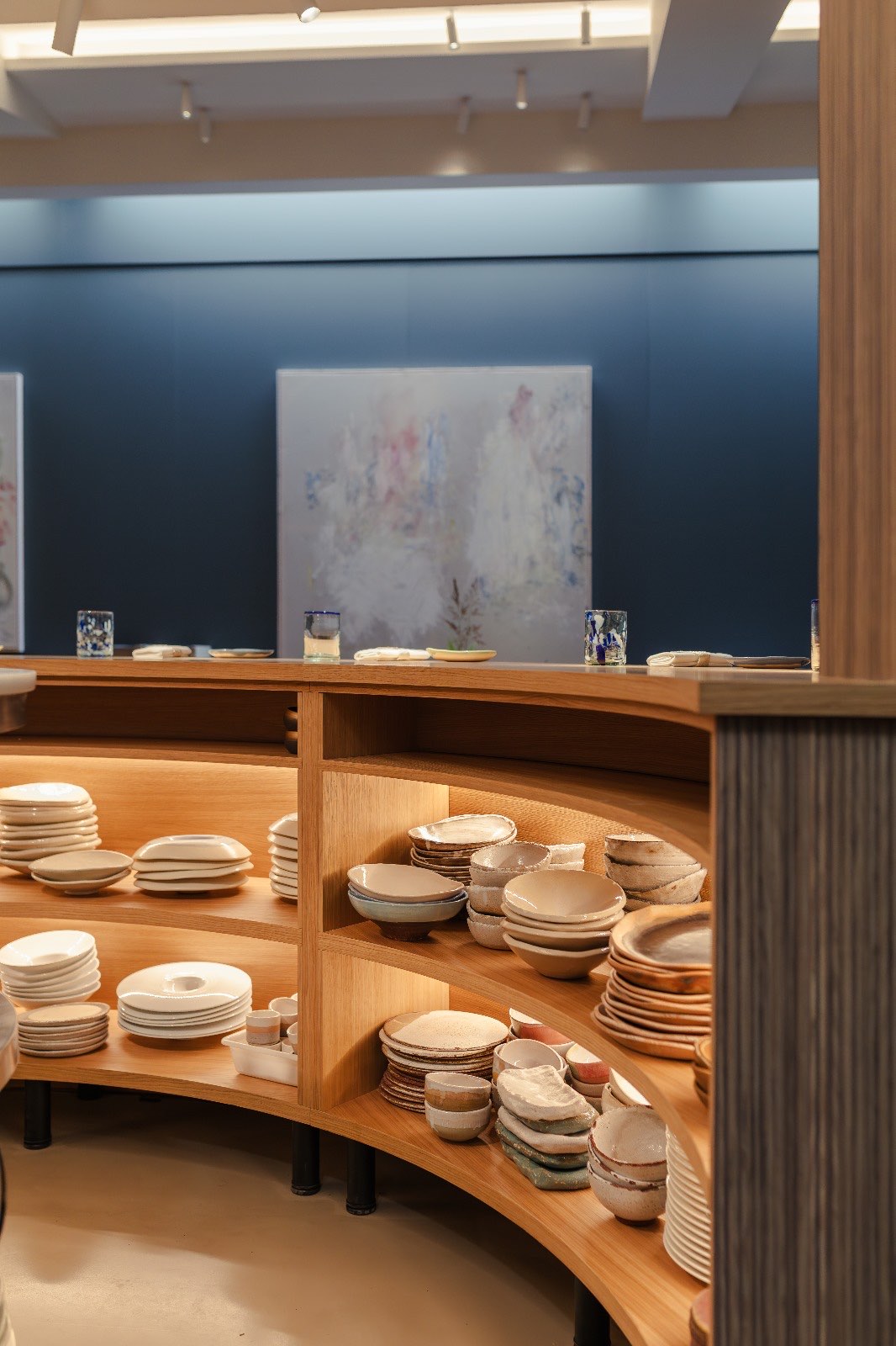 Estantería curva de roble bajo la barra del restaurante Riff, en Valencia